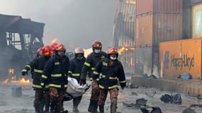 Les pompiers en train d'évacuer le corps d'une victime de l'explosion survenue au Bangladesh ce dimanche.