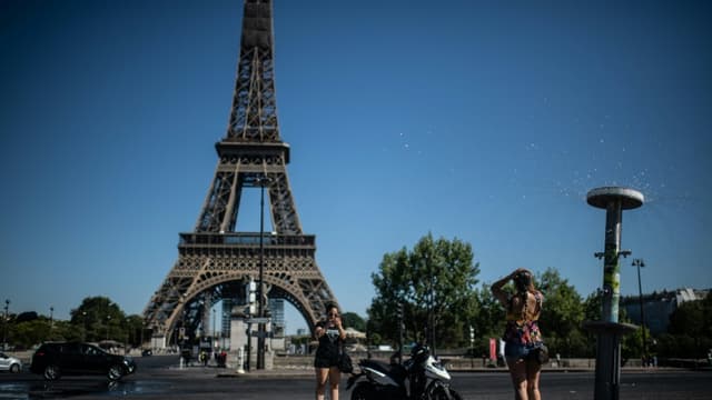 Rafraichissement grâce à une fontaine à Paris près de la Tour Eiffel, le 7 août 2020