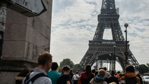 Des passants devant la Tour Eiffel à Paris, le 29 avril 2022
