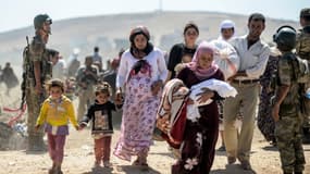 Des Kurdes de Syrie fuyant les jihadistes de l'Etat islamique passent la frontière turque, le 20 septembre 2014.