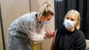 Une femme sapeur pompier vaccine une patiente, à Vailhauques (sud de la France), le 13 mars 2021.