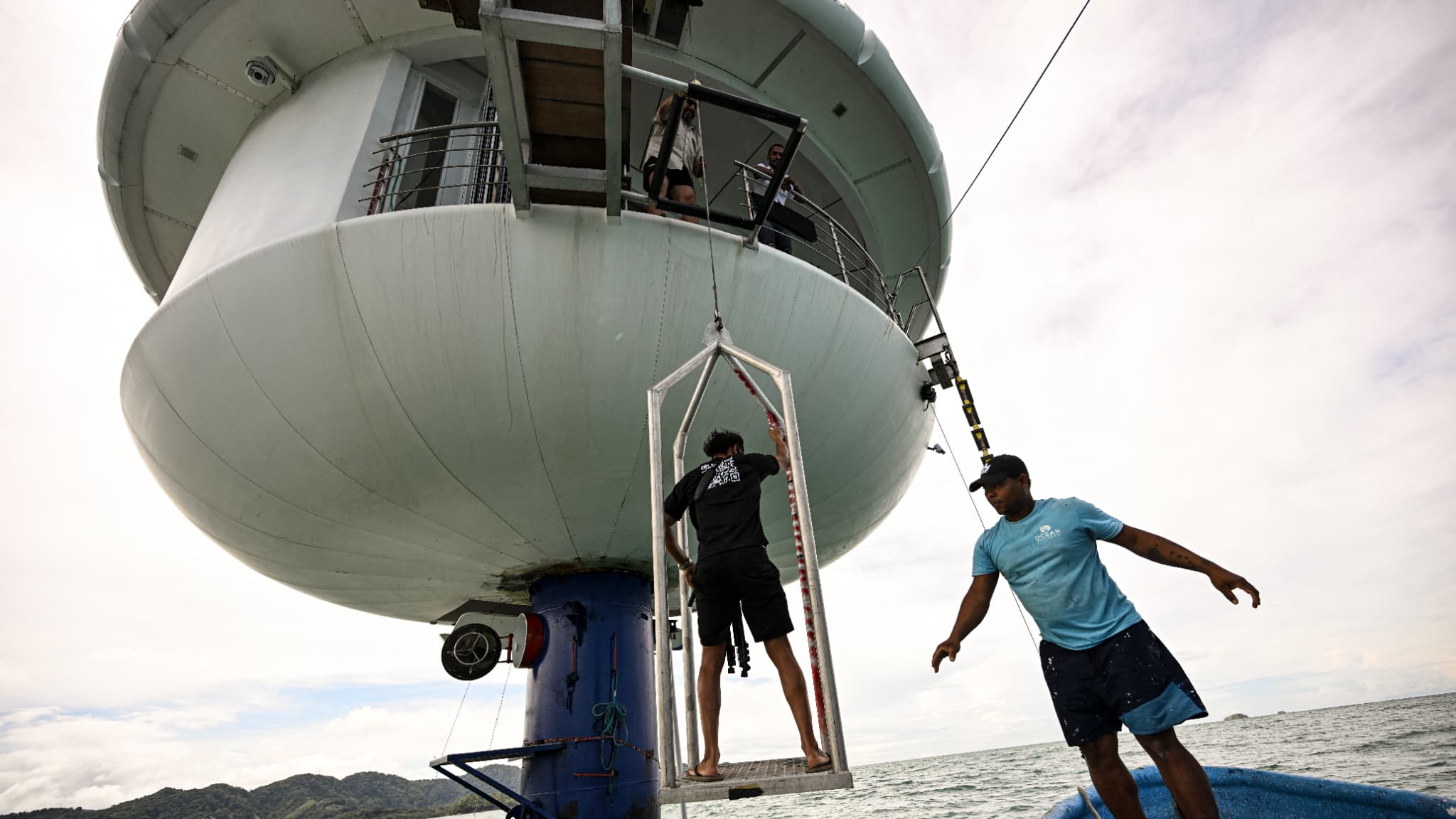 Un Panaméen descend de la maison "SeaPod Alpha Deep", située juste au-dessus de la capsule sous-marine dans laquelle Rudiger Koch tente de battre un record du monde au large de Puerto Lindo, au Panama. Le 26 novembre 2024.