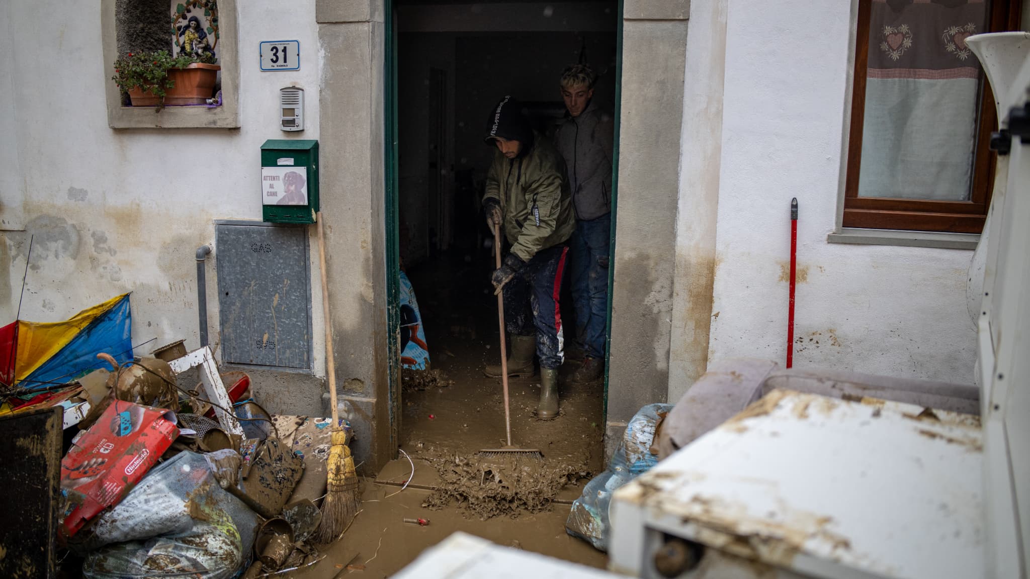 Des hommes nettoient une maison inondée à Montemurlo, à côté de Prato (Toscane, Italie), le 3 novembre 2023 après le passage de la tempête Ciaran Des hommes nettoient une maison inondée à Montemurlo, à côté de Prato (Toscane, Italie), le 3 novembre 2023 après le passage de la tempête Ciaran