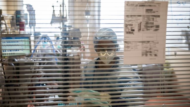 Une soignante dans la chambre d'un patient atteint du Covid-19 dans l'unité de soins intensifs du Centre hospitalier privé de l'Europe, le 25 mars 2021 au Port-Marly, près de Paris