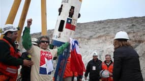 Mario Gomez (au centre), qui à 63 ans était le plus âgé des 33 mineurs bloqués bloqués depuis plus de deux mois au Chili à 600 mètres de fond, a retrouvé l'air libre mercredi, comme déjà plus d'une dizaine de ses collègues vers 13h00 GMT. L'opération de s