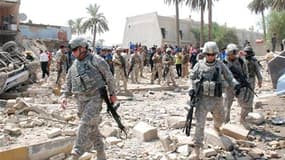 Soldats américains sur les lieux d'un attentat à Kout, dans le sud de l'Irak. Moins d'une semaine avant le retrait d'Irak des forces de combat américaines, une soixantaine de personnes ont péri mercredi dans le pays, victimes d'une série d'attentats suici