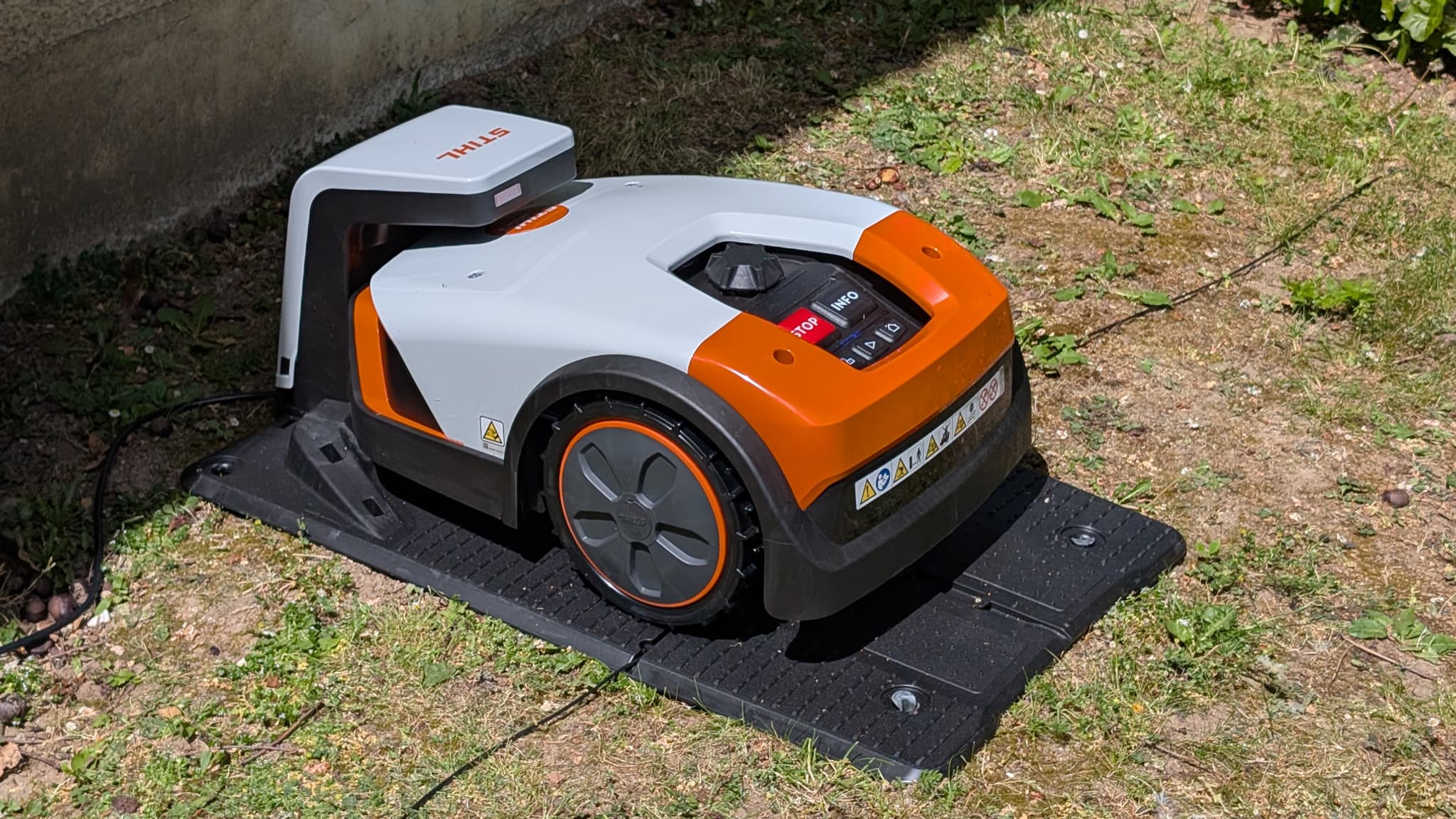 Le robot-tondeuse sur sa base, qui attend les ordres pour s’activer. Le robot-tondeuse sur sa base, qui attend les ordres pour s’activer.