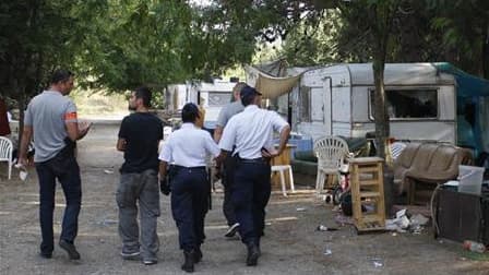 Inspection de policiers d'un camp rom à proximité d'Aix-en-Provence jeudi. Malgré l'émoi de l'opinion internationale, la France poursuit sa politique de démantèlement des camps occupés par des Roms et leur renvoi par avion en Roumanie ou en Bulgarie. /Pho