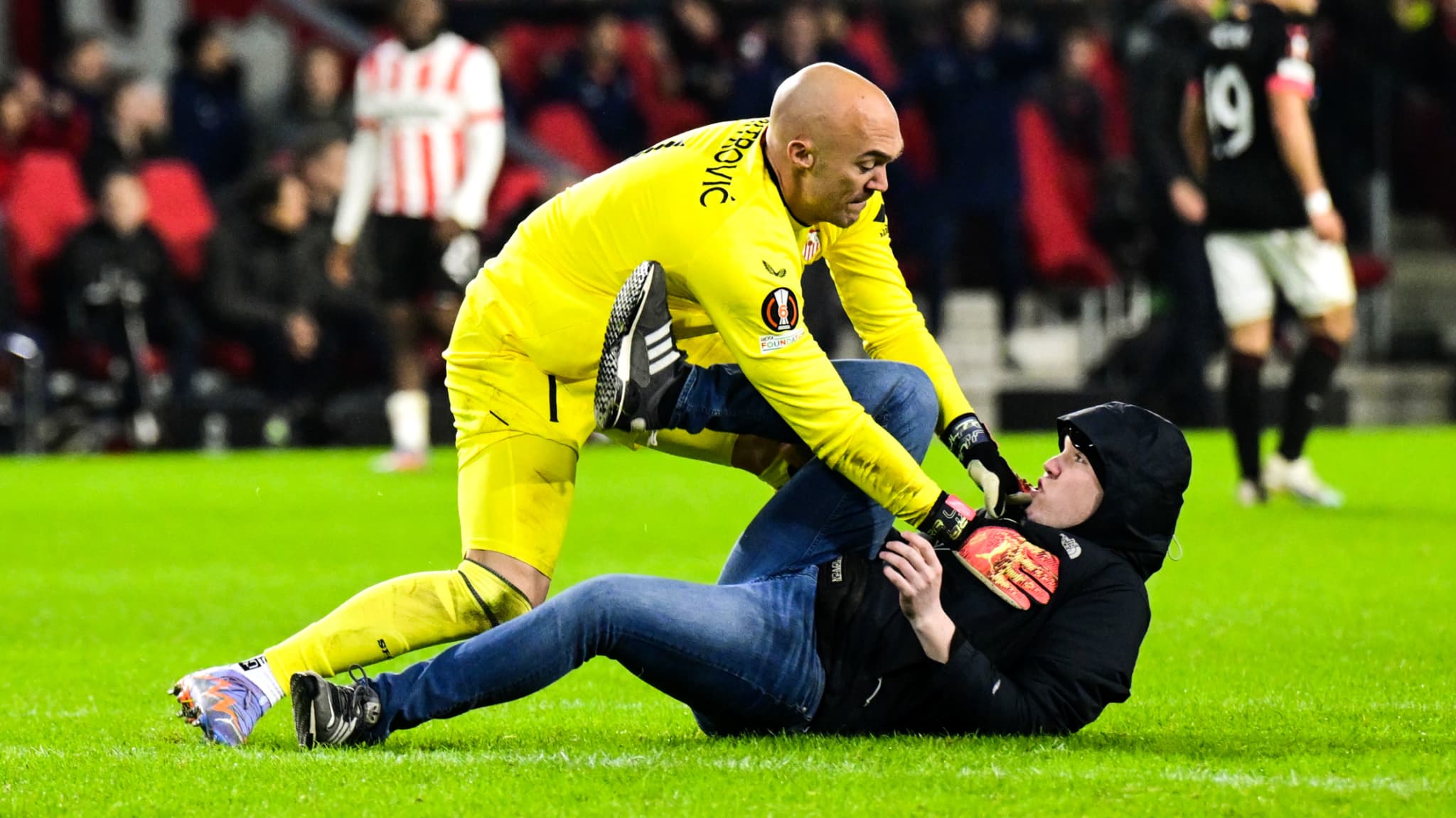 Marko Dmitrovic, gardien du Séville FC, a été agressé sur la pelouse par un striker en fin de rencontre lors du barrage retour de Ligue Europa au PSV Eindhoven Marko Dmitrovic, gardien du Séville FC, a été agressé sur la pelouse par un striker en fin de rencontre lors du barrage retour de Ligue Europa au PSV Eindhoven