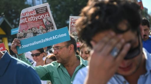 Un journaliste de Cumhuriyet brandit une pancarte avec le slogan "le journalisme n'est pas un crime", le 24 juillet 2017 devant le tribunal d'Istanbul