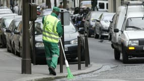 Un employé des services de propreté de la ville de Paris balaie un caniveau dans une rue de la capitale, le 22 septembre 2003.