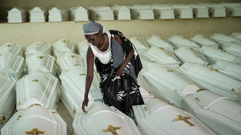 Une survivante du génocide rwandais de 1994 ouvre les cercueils contenant les restes des victimes au Mémorial du génocide de Nyanza avant un enterrement de masse à Kigali le 2 mai 2019.