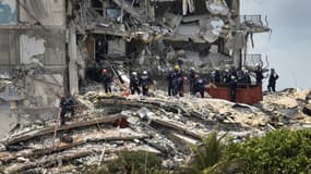 Des sauveteurs recherchent des survivants dans les ruines de l'immeuble partiellement effondré, le 26 juin 2021 à Surfside, en Floride