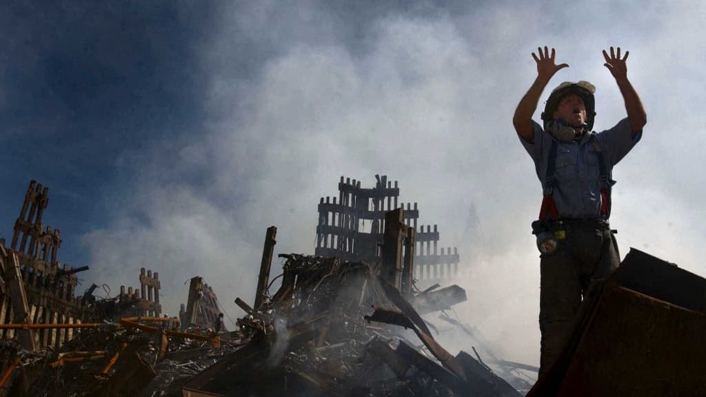 Un pompier new yorkais réclamant 10 sauveteurs supplémentaires dans la zone sinistrée par l'effondrement des deux tours, le 15 septembre 2001. Un pompier new yorkais réclamant 10 sauveteurs supplémentaires dans la zone sinistrée par l'effondrement des deux tours, le 15 septembre 2001.
