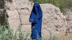 Une femme afghane vêtue d'une burqa marche le long d'un sentier dans le district de Sangin, dans la province de Helmand, le 27 août 2024.