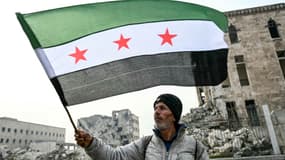 Un homme brandit un drapeau de l'opposition syrienne à Alep, dans le nord de la Syrie, le 11 décembre 2024.