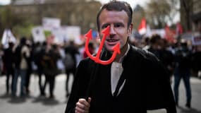 Un homme portant un masque d'Emmanuel Macron, le 11 avril 2018 lors d'une manifestation à Paris. 
