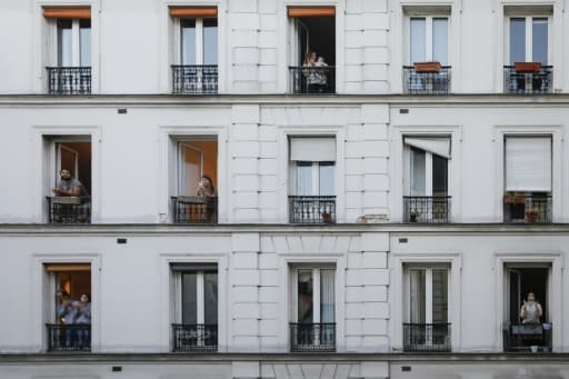 Des personnes à la fenêtre de leurs appartements applaudissent les personnels soignants, le 30 mars 2020 à Paris pendant confinement instauré en France Des personnes à la fenêtre de leurs appartements applaudissent les personnels soignants, le 30 mars 2020 à Paris pendant confinement instauré en France