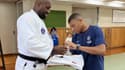 Kylian Mbappé signe un autographe sur un kimono tendu par Teddy Riner, ce jeudi 22 juillet 2022 à Tokyo