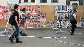 Des passants devant des affiches électorales pour les scrutins du 26 mai 2019 en Belgique (photo prise le 18 mai 2019 à Bruxelles)