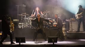 Johnny Hallyday sur scène, entouré de ses musiciens.