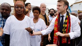 Le président français Emmanuel Macron réagit à côté d'un membre du personnel médical au centre hospitalier de Mayotte à Mamoudzou, le 19 décembre 2024