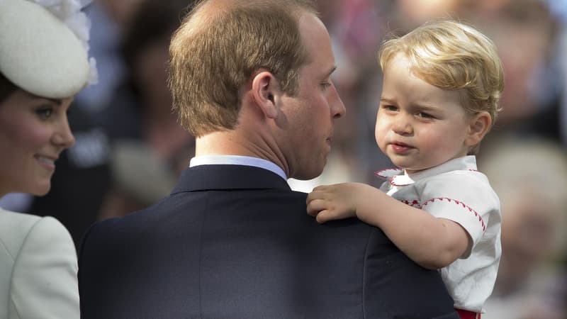 Le prince George dans les bras de son père lors du baptême de sa sœur, la princesse Charlotte, le 5 juillet 2015