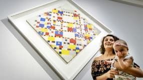 Une femme porte un bébé choisi parmi un groupe de 400, pour admirer en exclusivité des oeuvres de Piet Mondrian, le 11 juillet 2017 au Gemeentemuseum de La Haye