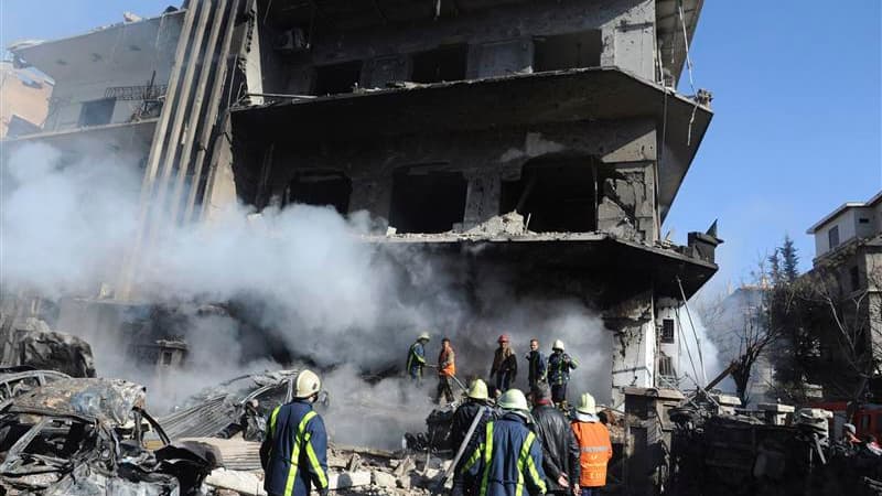 Pompiers syriens sur les lieux d'une explosion à Damas. Plusieurs civils et des membres des forces de l'ordre syriennes ont été tués samedi par deux explosions qui se sont produites aux abords de centres des services de sécurité dans la capitale syrienne,