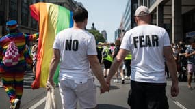 Deux hommes portant des t-shirts "No Fear" participent à la marche des fiertés à Berlin en Allemagne le 24 juillet 2021. (PHOTO D'ILLUSTRATION)