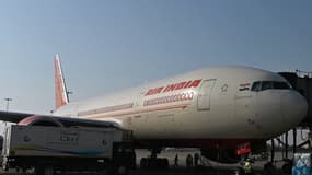 Des membres du personnel au sol se tiennent à côté d’un avion d’Air India sur le tarmac de l’aéroport international Indira Gandhi à New Delhi le 8 octobre 2021