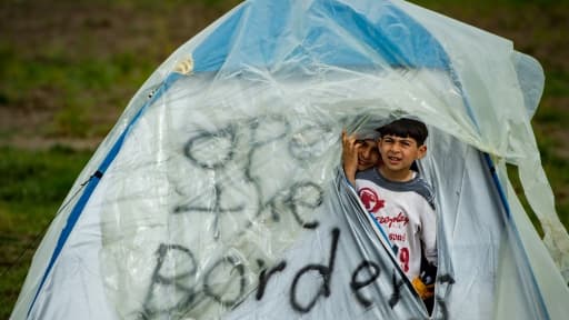 Deux garçons dans une tente marquée "Ouvrez les frontières" dans un camp de migrants à la frontière gréco-macédonienne près du village d'Idomeni le 24 mars 2016