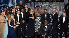 Le réalisateur britannique Steve Mc Queen au centre recevant l'Oscar du meilleur film aux côtés de son co-producteur Brad Pitt