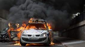 Le véhicule de police en feu, le 18 mai, quai de Valmy, à Paris.