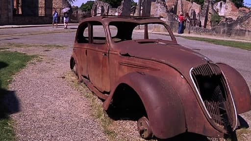 Carcasse d'une voiture calcinée dans les ruines du village martyr d'Oradour-sur-Glane, en Haute-Vienne, ce lundi.