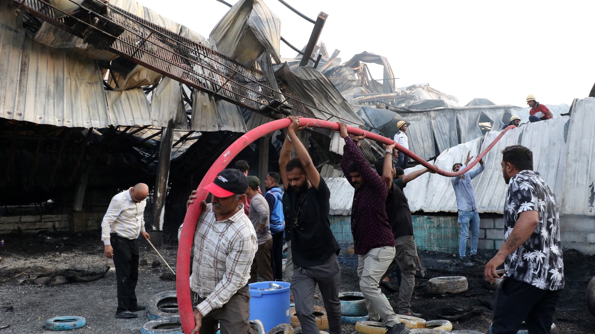 Des pompiers tentent d'éteindre un incendie qui s'est déclaré dans un parc d'attractions à Rajkot, dans l'État indien du Gujarat, le 25 mai 2024. Des pompiers tentent d'éteindre un incendie qui s'est déclaré dans un parc d'attractions à Rajkot, dans l'État indien du Gujarat, le 25 mai 2024.