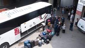 Un bus de réfugiés haïtiens, qui fuient les Etats-Unis pour demander l'asile au Canada, arrive au stade olympique de Montréal, le 3 août 2017