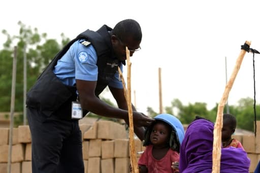 Un Casque bleu de la Minusma prête son casque à un enfant à Gao, au Mali, le 3 août 2018