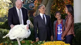 Le président Barack Obama, entouré par ses deux filles Sasha et Malia, est resté fidèle à la tradition de Thanksgiving en graciant mercredi symboliquement deux dindes censées finir dans les assiettes des Américains le jour de la fête du "Merci-Donnant". /