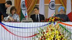 A New Delhi, Nicolas Sarkozy entouré du Premier ministre indien Manmohan Singh et de la présidente du directoire d'Areva Anne Lauvergeon Le groupe français a signé lundi deux accords visant la fourniture d'au moins deux réacteurs nucléaires de type EPR à