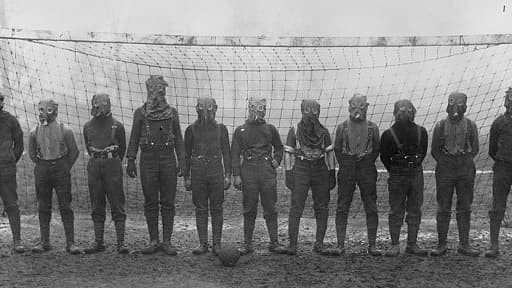 Soldats britaniques jouant au football avec des masques contre le gaz, quelque part en France, Première Guerre Mondiale (1914-1918).