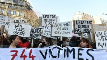 Des femmes dénoncent sur des pancartes les victimes de violences conjugales en France, lors d'une manifestation le 8 mars 2022 à Paris pour la journée internationale pour les droits des femmes