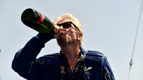Le milliardaire Richard Branson boit du champagne après avoir passé quelques minutes à la lisière de l'espace à bord de son engin VSS Unity, le 11 juillet 2021 au Spaceport America, au Nouveau-Mexique