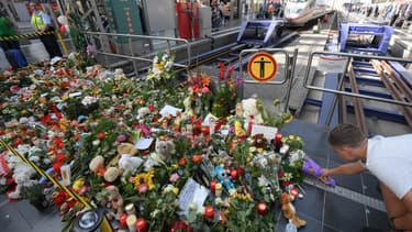 Un homme déposant des fleurs sur le lieu de l'homicide