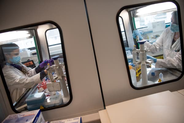 Des biologistes du laboratoire pharmaceutique OSE Immunotherapeutics travaillent sur un programme de développement d'un vaccin contre l'infection Covid-19, le 31 mars 2021 à Nantes, dans l'ouest de la France.