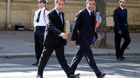 Nicolas Sarkozy et François Fillon arrivent ensemble au dernier conseil des ministres avant la pause estivale, durant lequel a été présenté le budget incluant l'aide à la Grèce, qui devrait être adopté en septembre et alourdira la dette de la France de 15