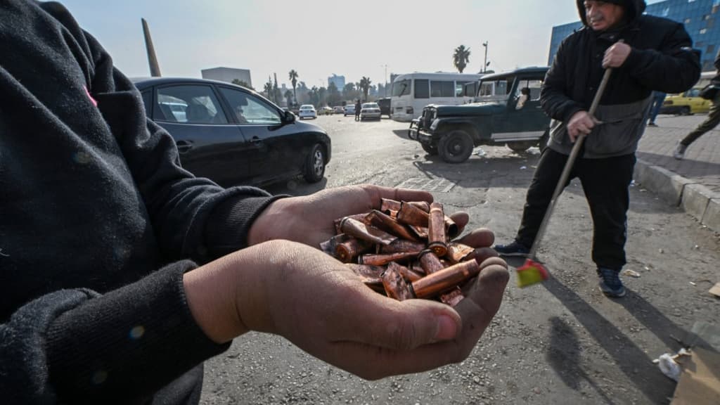 Des hommes balaient la rue pour enlever les projectiles sur la place des Omeyyades à Damas, le 10 décembre 2024. Des hommes balaient la rue pour enlever les projectiles sur la place des Omeyyades à Damas, le 10 décembre 2024.