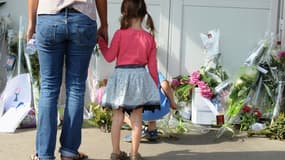 Des enfants déposent des fleurs devant l'entrée de l'école Edouard-Herriot, à Albi, le 5 juillet. Vendredi une enseignante a été mortellement poignardée par une mère d'élève.