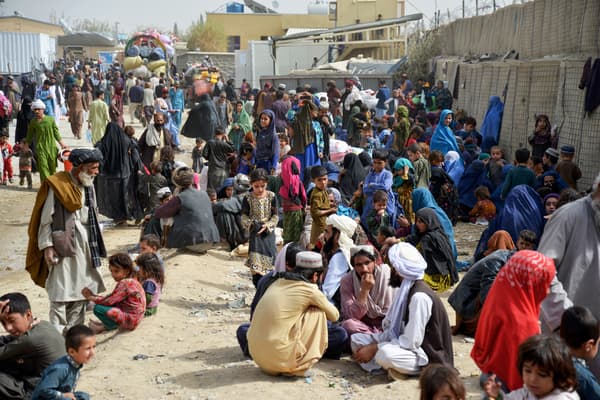 Sur cette photo prise le 1er novembre 2023, des réfugiés afghans attendent près d'un centre d'enregistrement à leur arrivée du Pakistan, à la frontière afghano-pakistanaise dans le district de Spin Boldak de la province de Kandahar. Plus de 165 000 Afghans ont fui le Pakistan depuis que le gouvernement pakistanais a ordonné à 1,7 million de personnes de quitter le pays sous peine d'être arrêtées et expulsées, ont indiqué des responsables le 2 novembre.