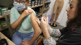 Une femme reçoit une dose du vaccin Comirnaty Omicron XBB 1.5 Pfizer contre le COVID-19 dans une pharmacie d'Ajaccio, le 5 octobre 2023, lors d'une nouvelle campagne de vaccination contre le COVID-19 sur l'île méditerranéenne française de Corse.